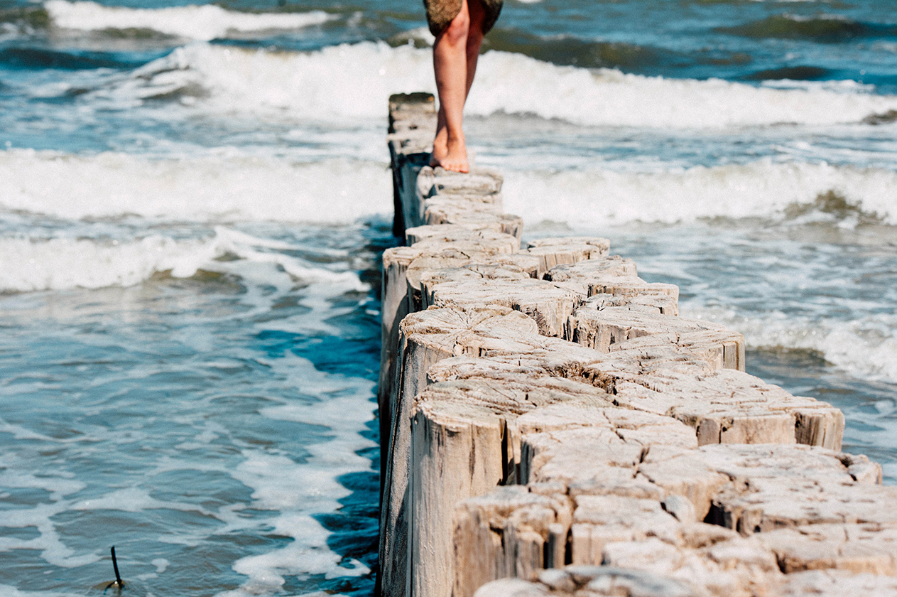 walking on wooden posts in ocean